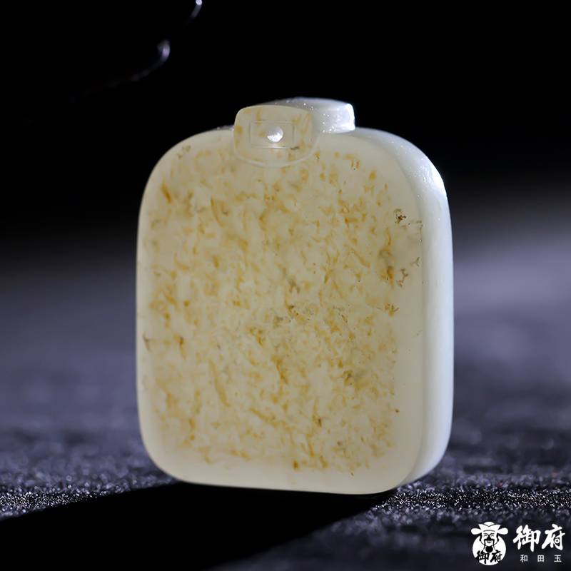 Close detail of the softly polished white jade and retained gold skin